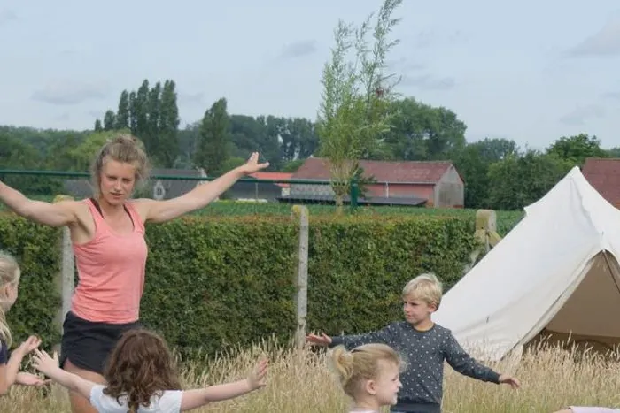 Kinderyoga met een groepje kinderen in het gras