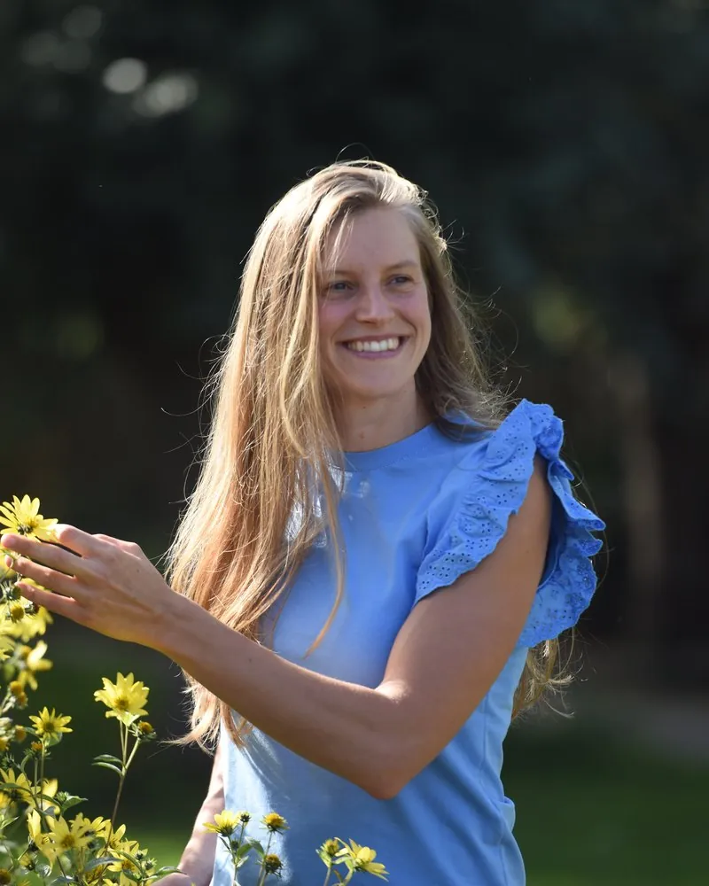 Linde Vandaele bij de bloemen in de tuin