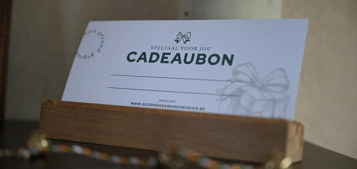 Een cadeaubon van Gezond Gegrond Groeien op een houten plankje